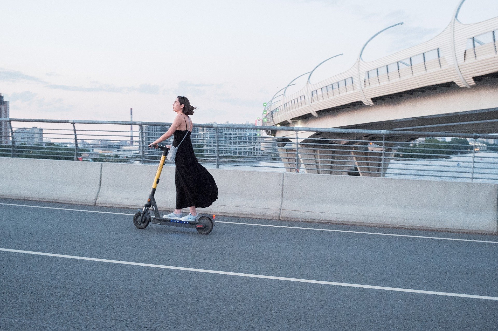 A photo of a woman riding an E-scooter.
